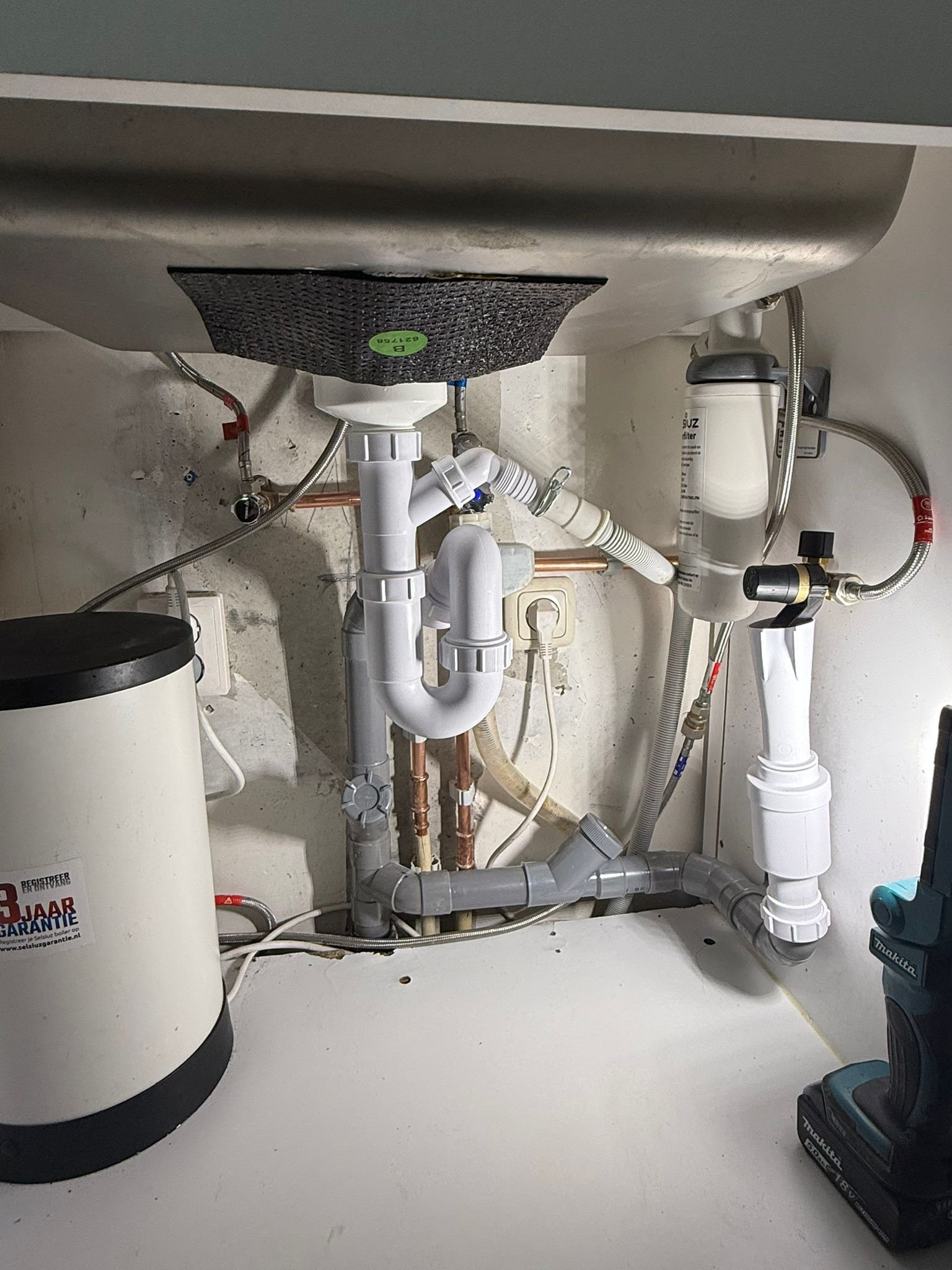 Waterleiding en afvoer aangesloten onder een keukenspoelbak